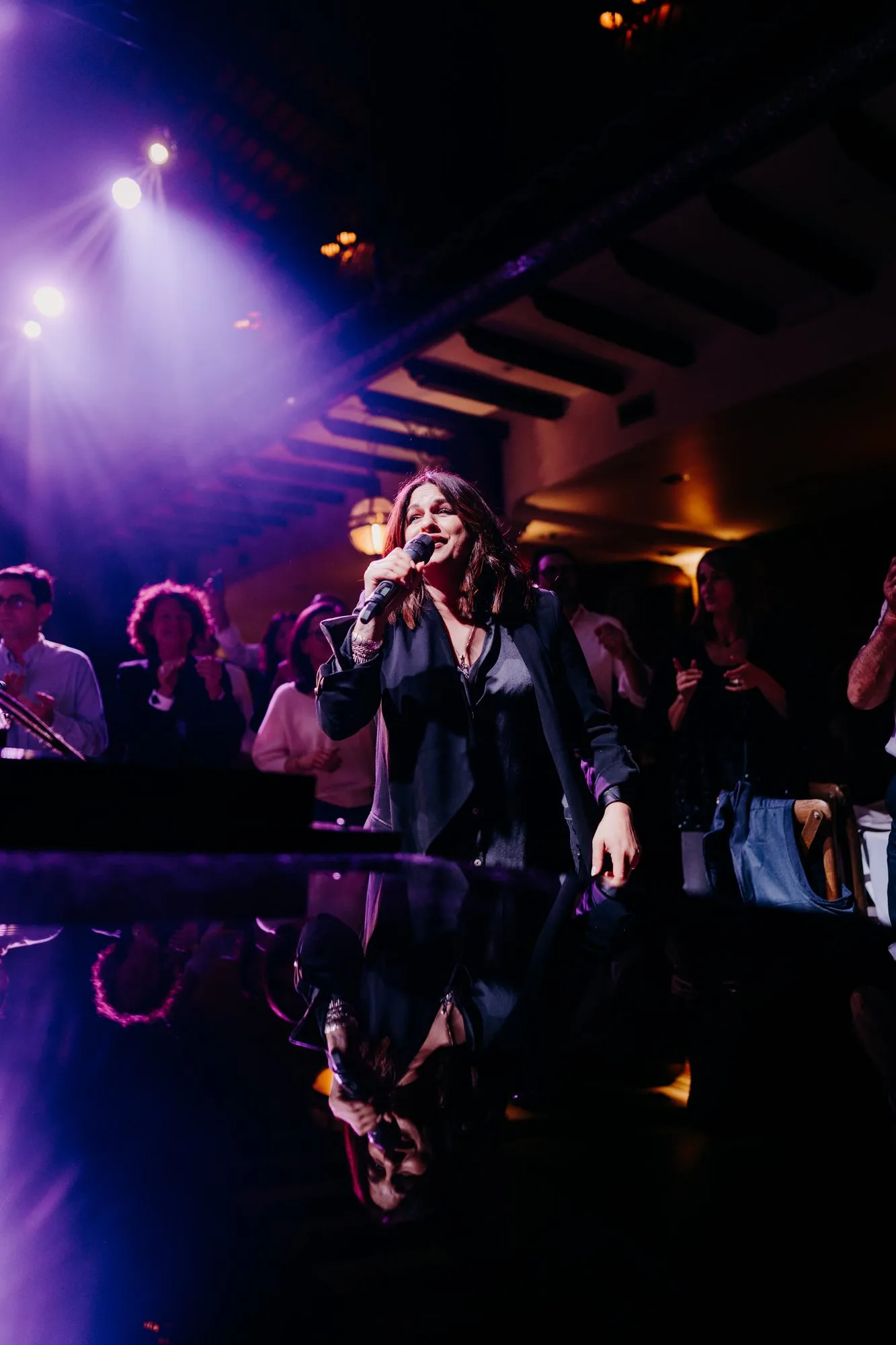 Chanteuse en concert sur scène, éclairage violet