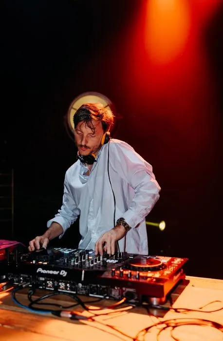 DJ aux platines dans un halo de lumière rouge