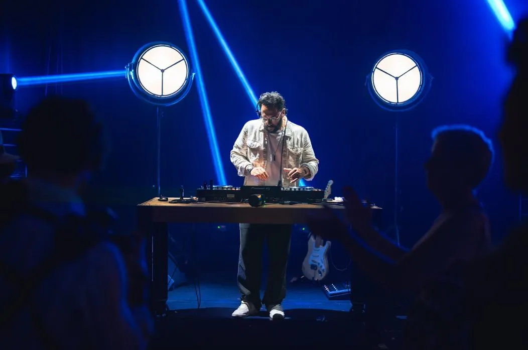 DJ en régie sur la scène du Patio, sous les faisceaux bleus