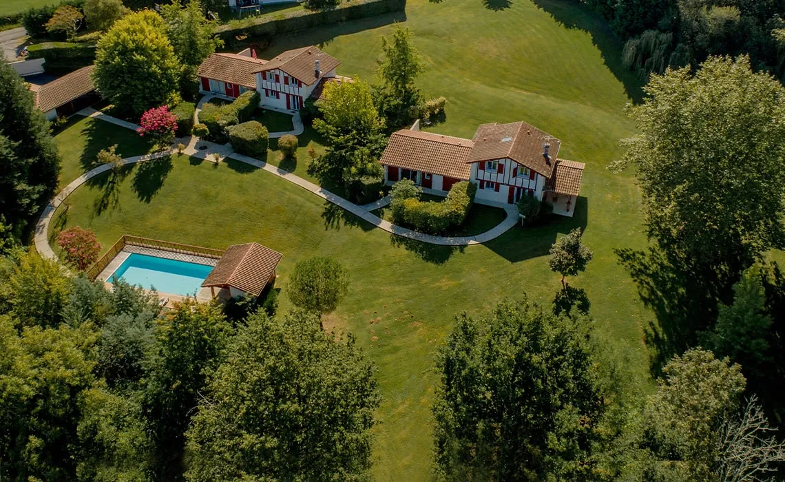 Vue aérienne des maisons partenaires, de leur piscine et de leur parc arboré, à quelques minutes à pied du Domaine