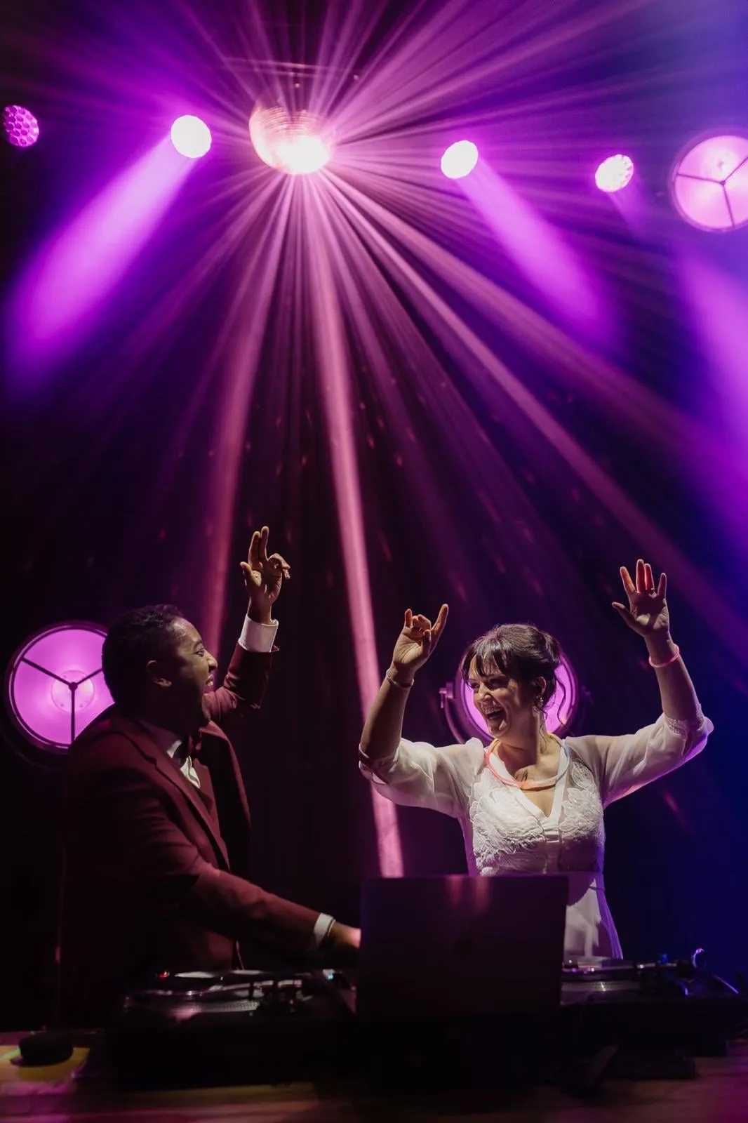 La mariée aux platines aux côtés du DJ, sous les lumières violettes
