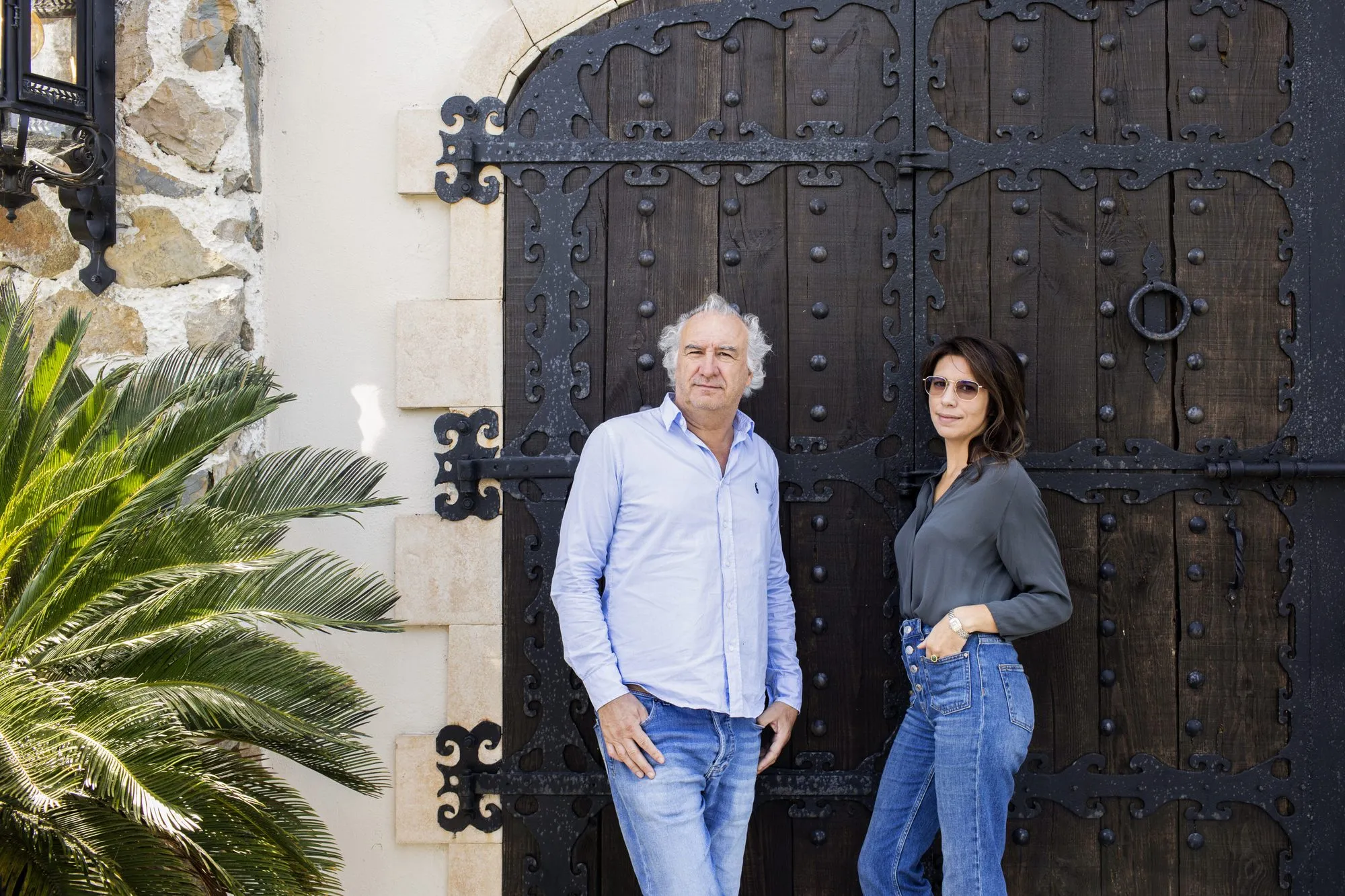 Portrait en duo devant le grand portail en bois clouté