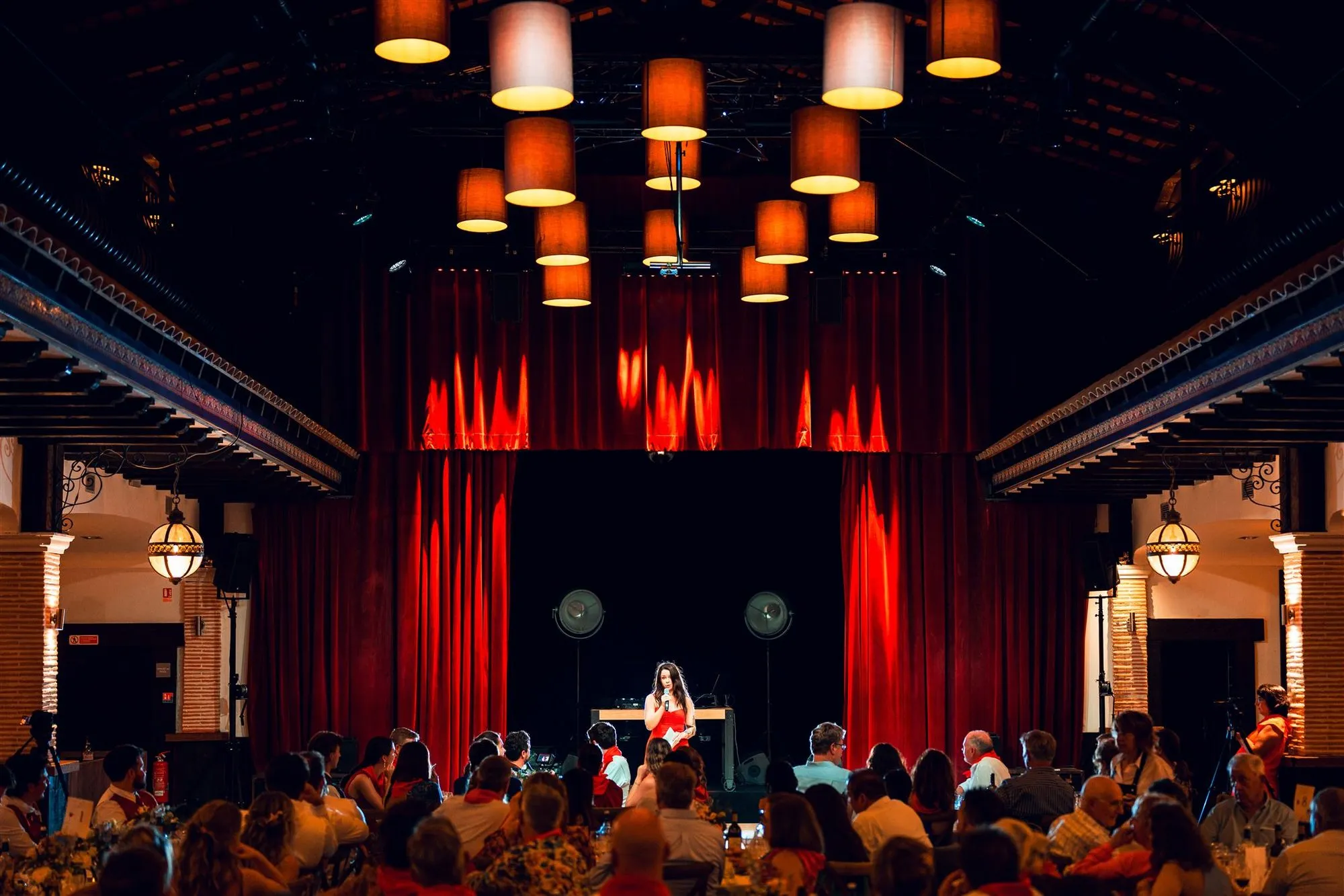 Le Patio en configuration spectacle : scène, rideau rouge et public attablé